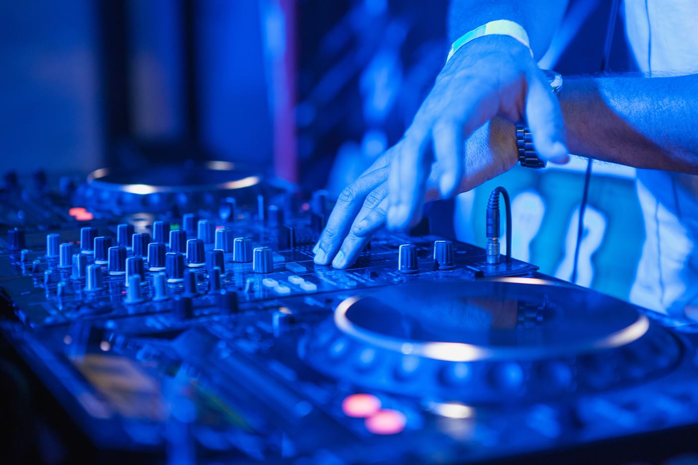 Mains d'un DJ professionnel sur une table de mixage